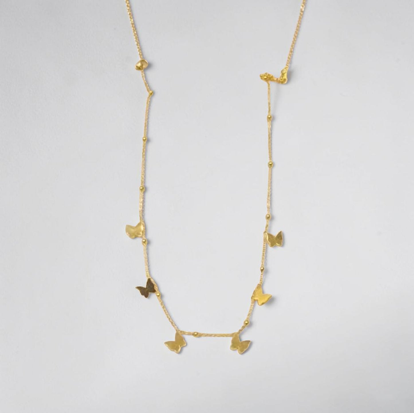 Gold necklace with butterfly pendants on a light gray background | Butterfly Necklace 18k gold plated water proof and stainless steel by Efforro Pakistan 